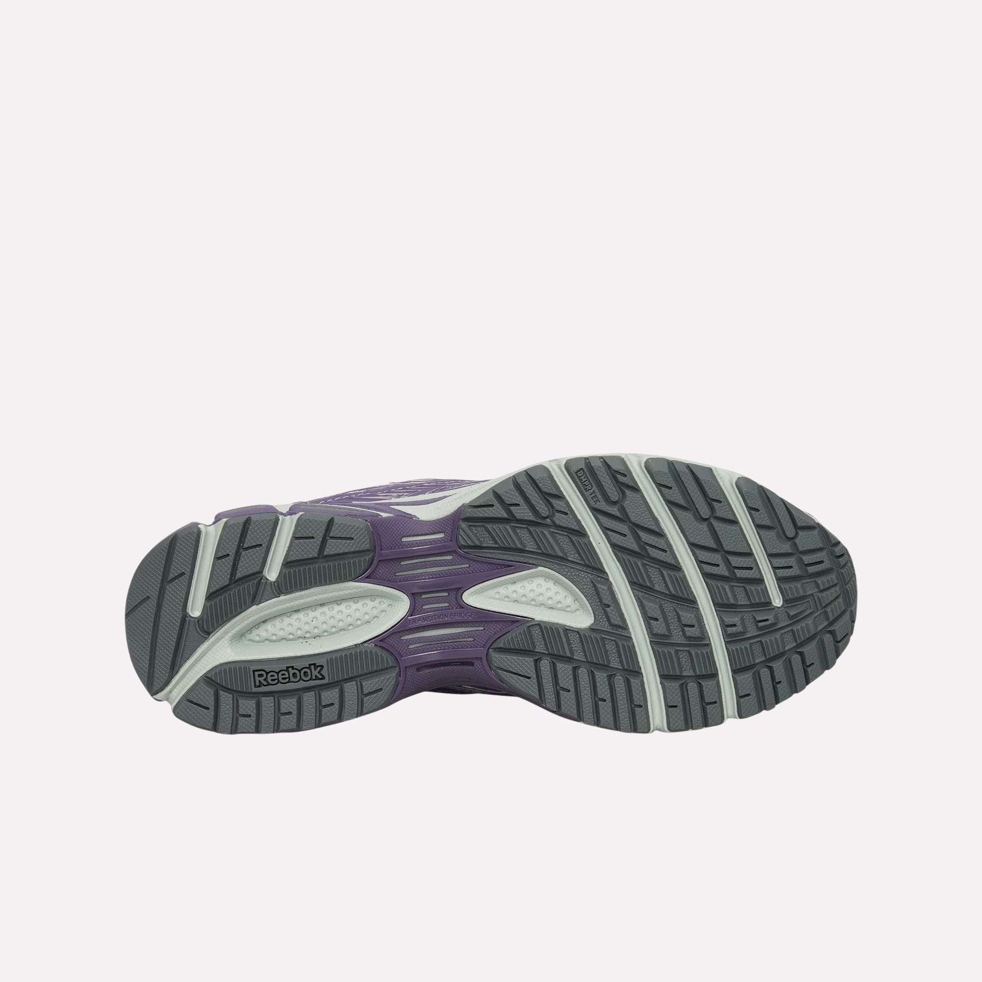 The image displays the outsole of the Reebok Premier Road Ultra Shoes, featuring a tread with dark gray, light gray, and purple sections for traction and support, as well as a dual-density midsole.