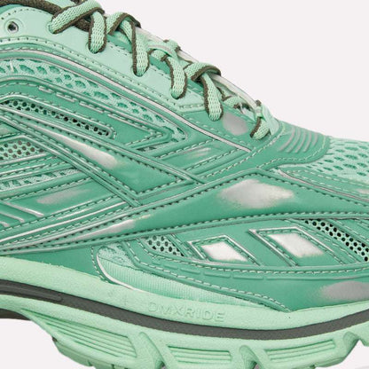 Close-up of Reebok Premier Road Ultra Shoes in green, featuring mesh and synthetic overlays, detailed stitching, DMXRIDE embossed on the sole, layered design accents, light green laces, and a dual-density midsole for comfort.
