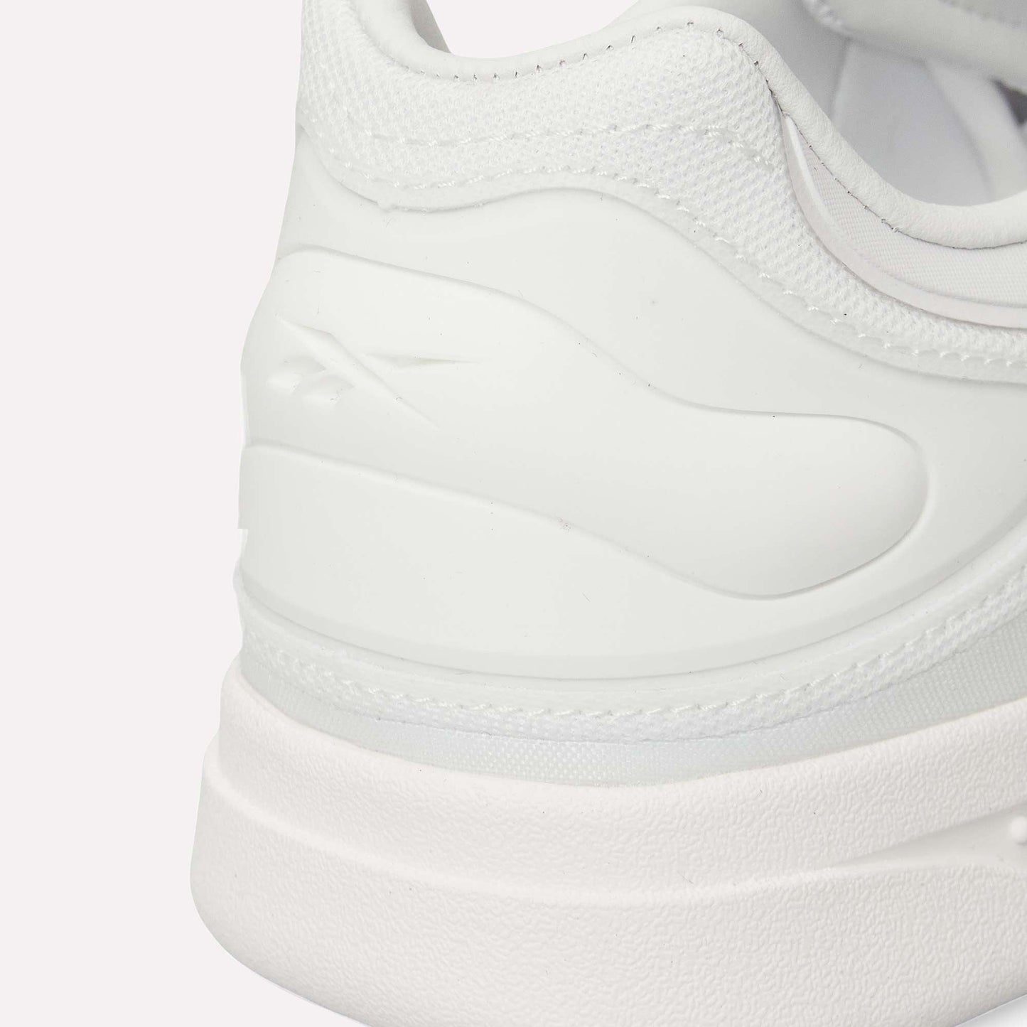 Close-up of the heel and side of Reebok Hammer Pro LTD Shoes with a subtle logo embossed on textured faux leather. Smooth and mesh materials combine with a durable rubber sole for a clean, minimalistic look.