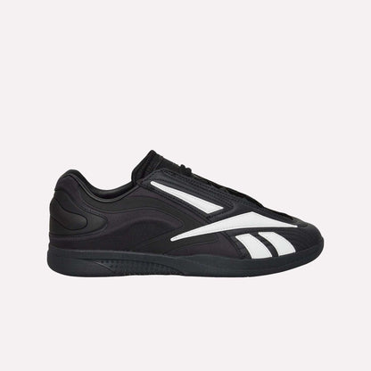 The Reebok Hammer Pro LTD Shoes, black faux leather low-tops with white stripes and a durable rubber sole, are shown in side profile against a plain white background.