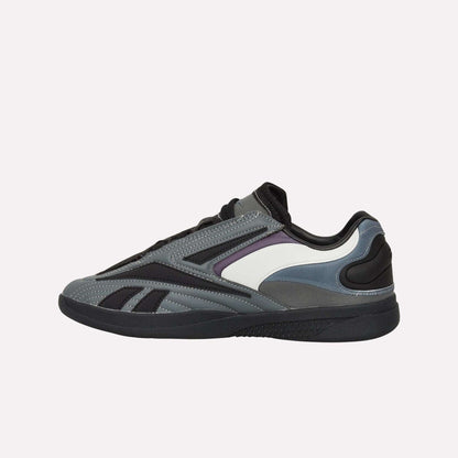 The Reebok Hammer Pro LTD Shoes are athletic sneakers in gray, black, and white with purple accents. They feature a sleek faux leather build, black sole, and layered panels. Shown in side profile on a white background.