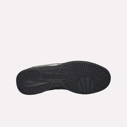 A bottom view of the Reebok Hammer Pro LTD Shoes shows a textured rubber sole with diverse patterns and a central Reebok logo, while the faux leather upper gives these sneakers a sleek, modern look.