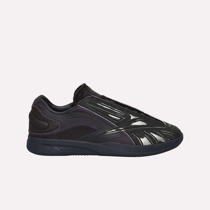 A black Reebok Hammer Pro LTD Shoe with a glossy, textured faux leather upper, mesh and synthetic overlays, and a durable rubber sole, shown in side profile on a white background.