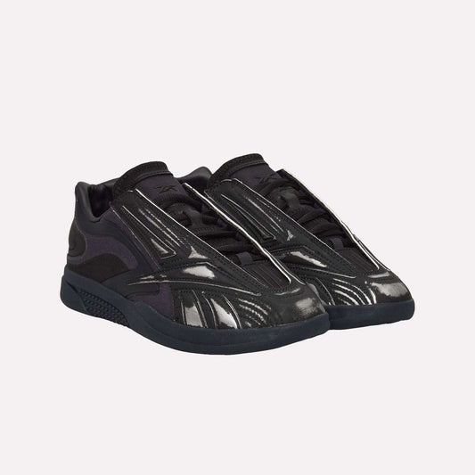 A pair of black Reebok Hammer Pro LTD Shoes with a faux leather upper, reflective accents, and a sturdy rubber sole, displayed on a white background.