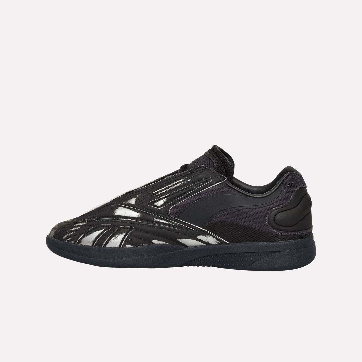 A black Reebok Hammer Pro LTD Shoe with a sleek low-top design, glossy faux leather upper, and durable rubber sole, shown side view on a white background.
