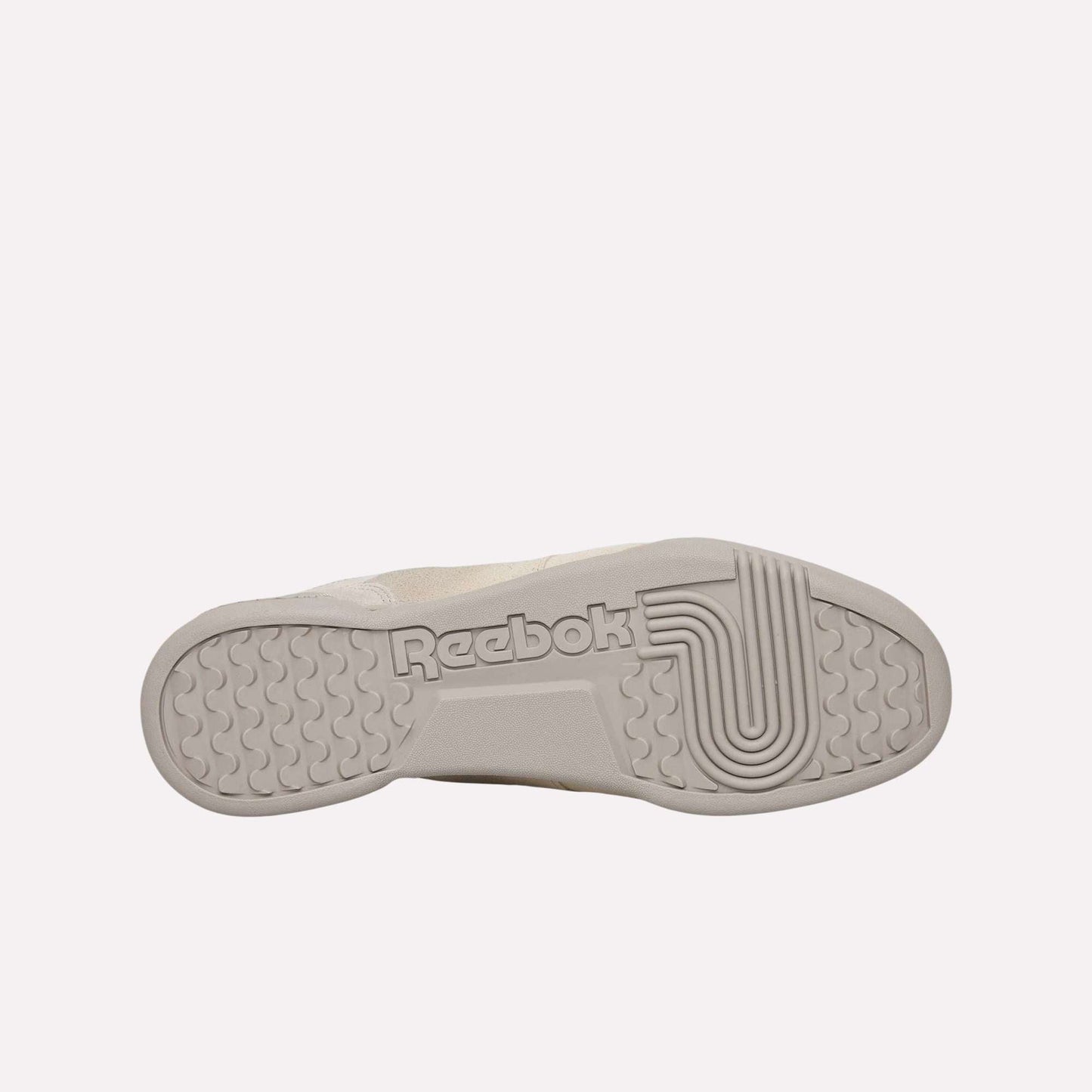 The image displays the sole of a Reebok Workout Plus OG shoe, showcasing the Reebok logo and distinctive textured details, set against a light blue background that highlights its classic retro silhouette.
