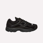 The Reebok Pleasures Premier Trinity KFS Shoes feature a black athletic design with mesh and suede details, black laces, a textured rubber sole, and subtle Reebok branding. Displayed on a light blue background.