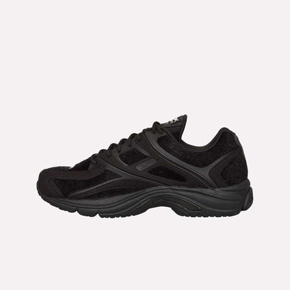 The Reebok Pleasures Premier Trinity KFS Shoes feature a black textured pony hair upper and thick sole, showcased in profile on a light blue background—a striking release from the latest Pleasures collaboration.