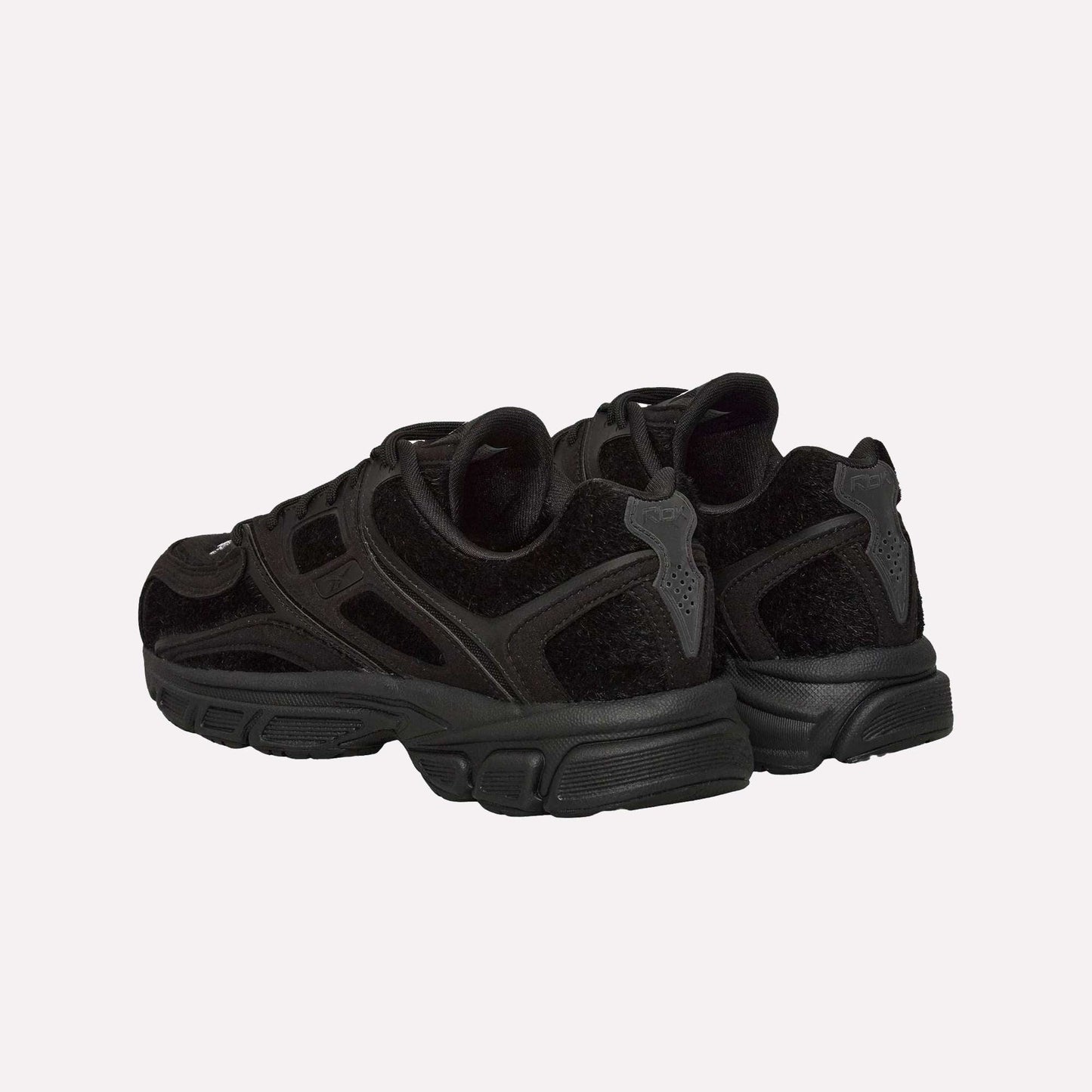 A pair of Reebok Pleasures Premier Trinity KFS Shoes with textured suede, mesh, and pony hair uppers, shown from the back and side against a plain light blue background.