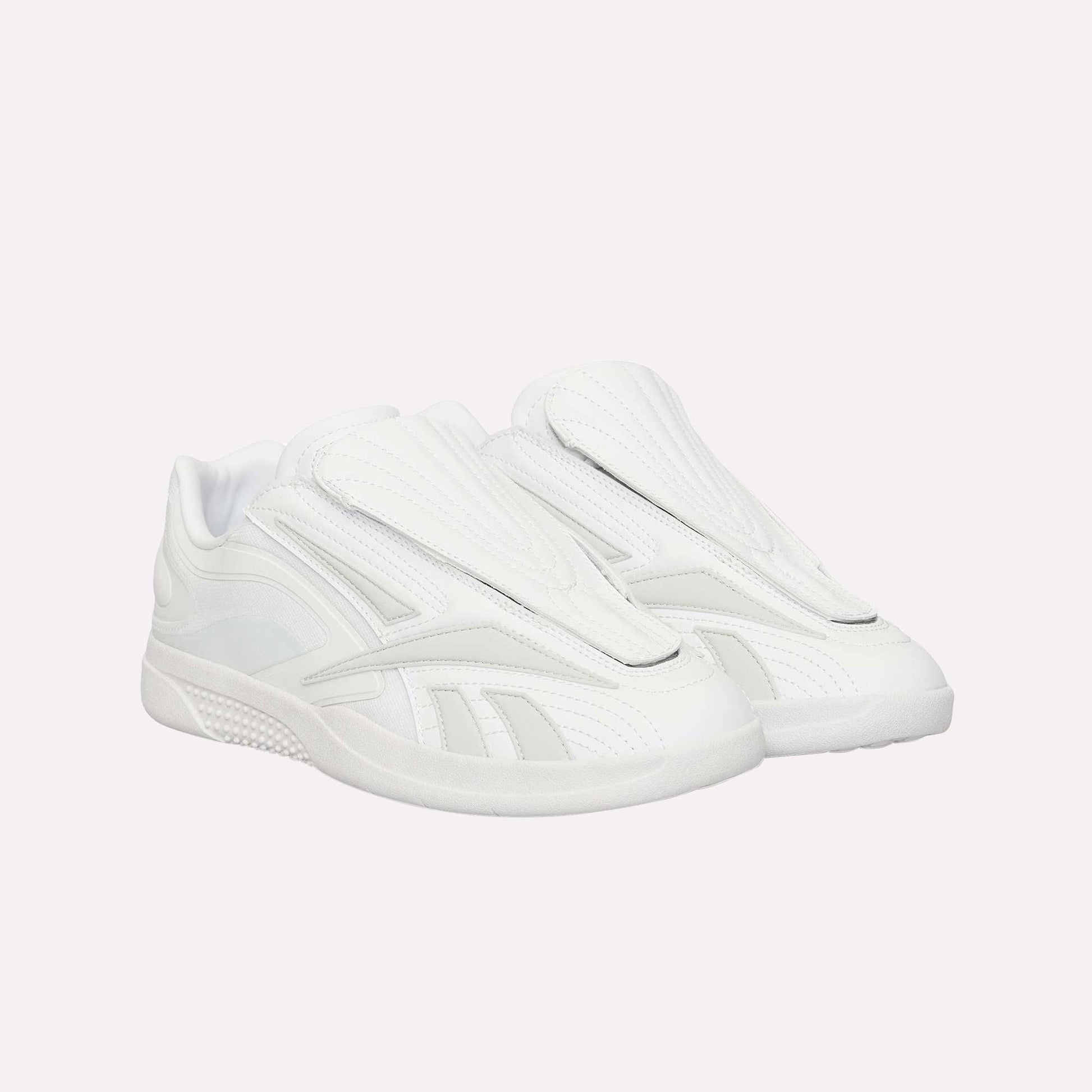 A pair of Reebok Hammer Pro Ltd sneakers, all white with a modern suede upper, closed tongue, and durable rubber sole, are pictured side by side against a white background.