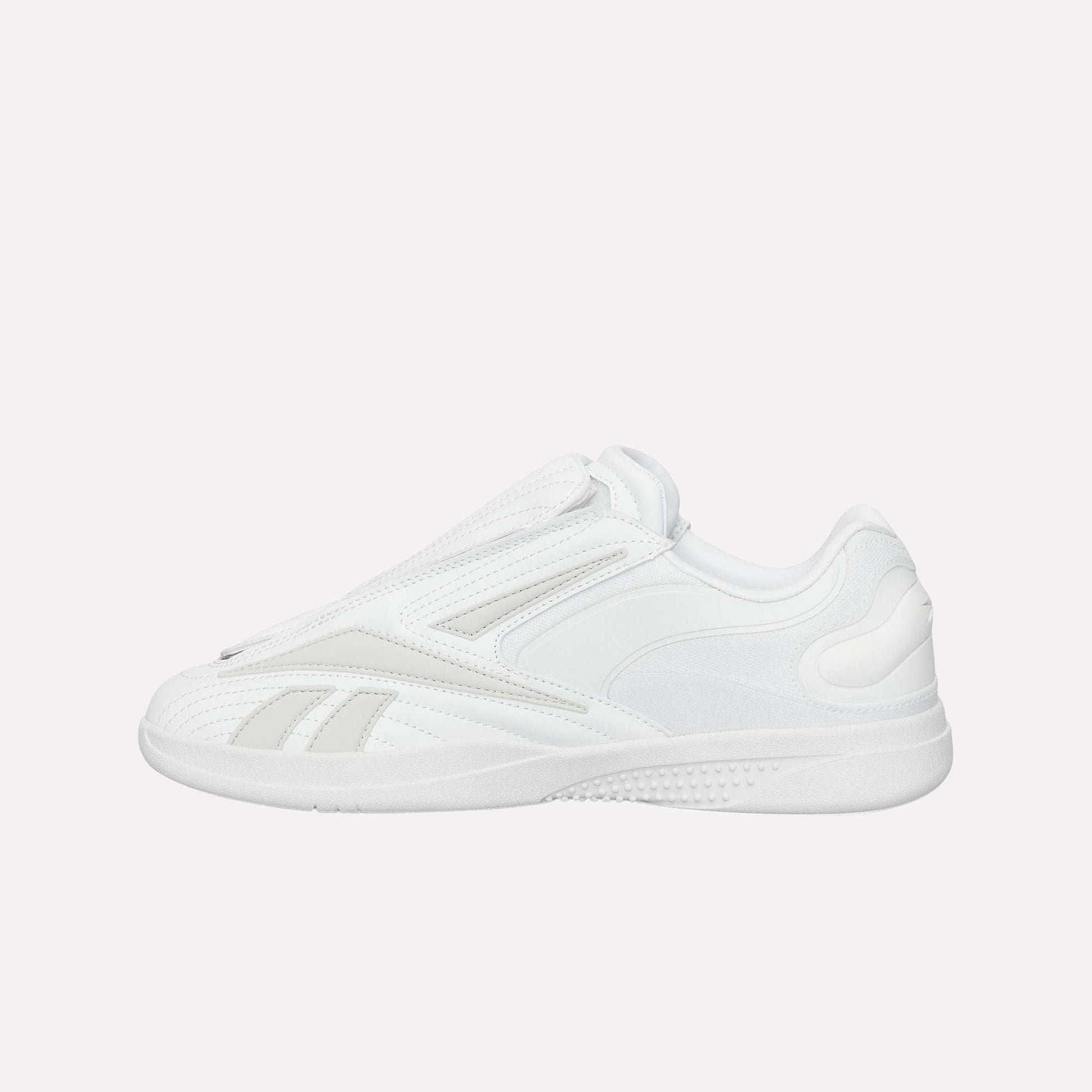 The Reebok Hammer Pro Ltd is a white low-top sneaker with a minimalist design, subtle stitching, durable rubber sole, and sleek lace-free suede upper for a modern look.