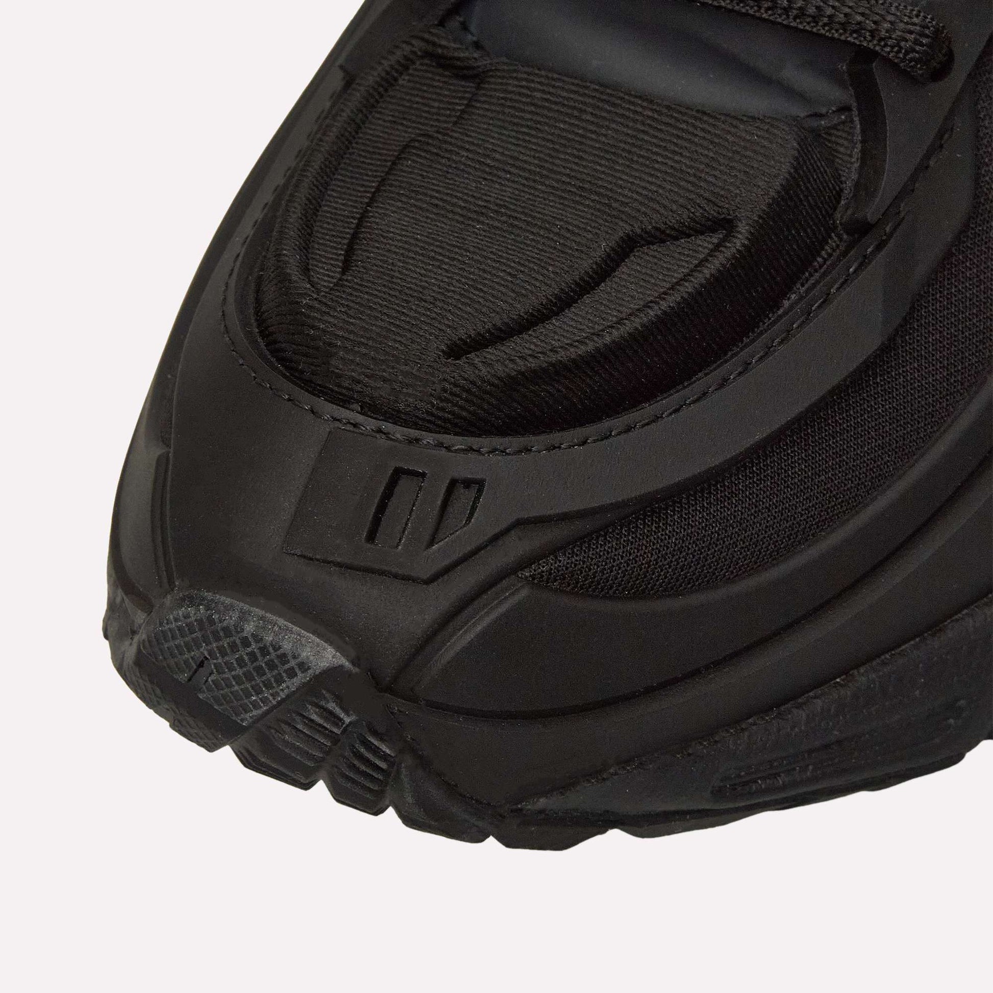 Close-up of the front of the Reebok Premier Road Modern, highlighting textured details, layered materials, and stitching on the toe and sides of this sleek black running shoe.