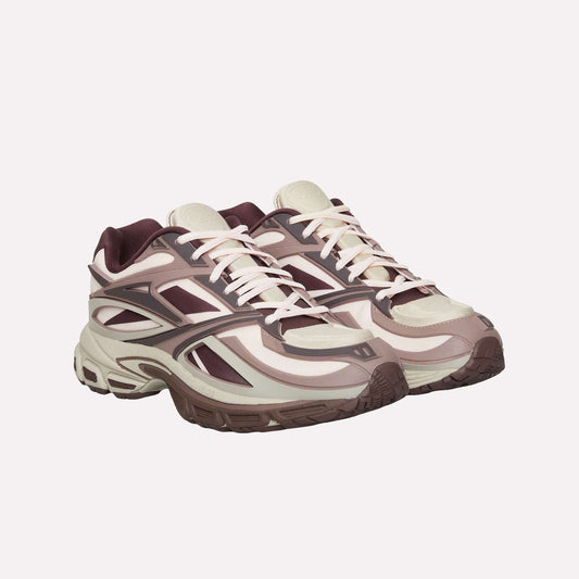 A pair of Reebok Premier Road Modern sneakers with beige, cream, and maroon accents, thick dual-density midsoles, patterned panels, and white laces are displayed side by side on a white background.