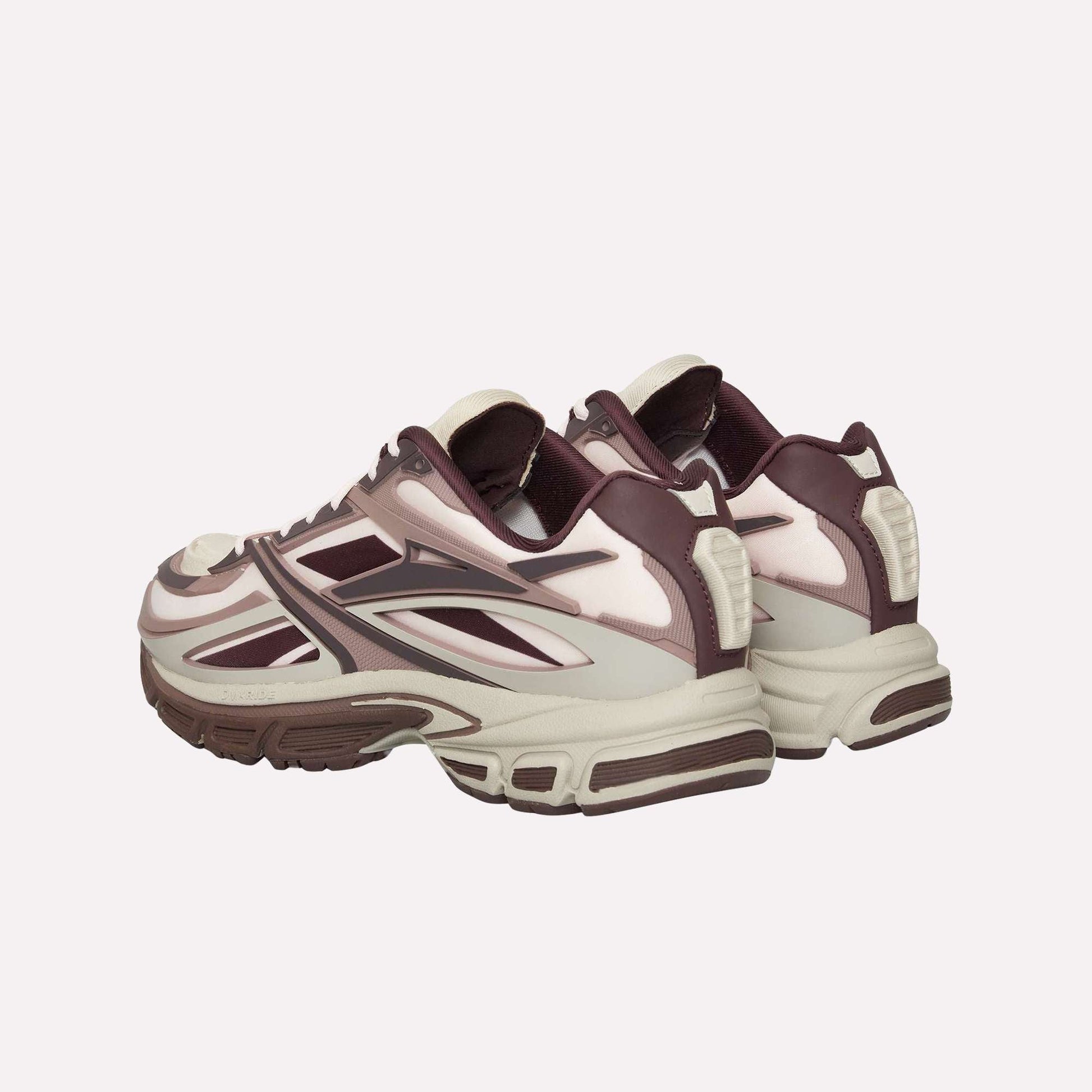 The Reebok Premier Road Modern sneakers feature a maroon, cream, and beige colorway with chunky soles and layered panels, shown from the back and side angles, inspired by archival running shoe design.