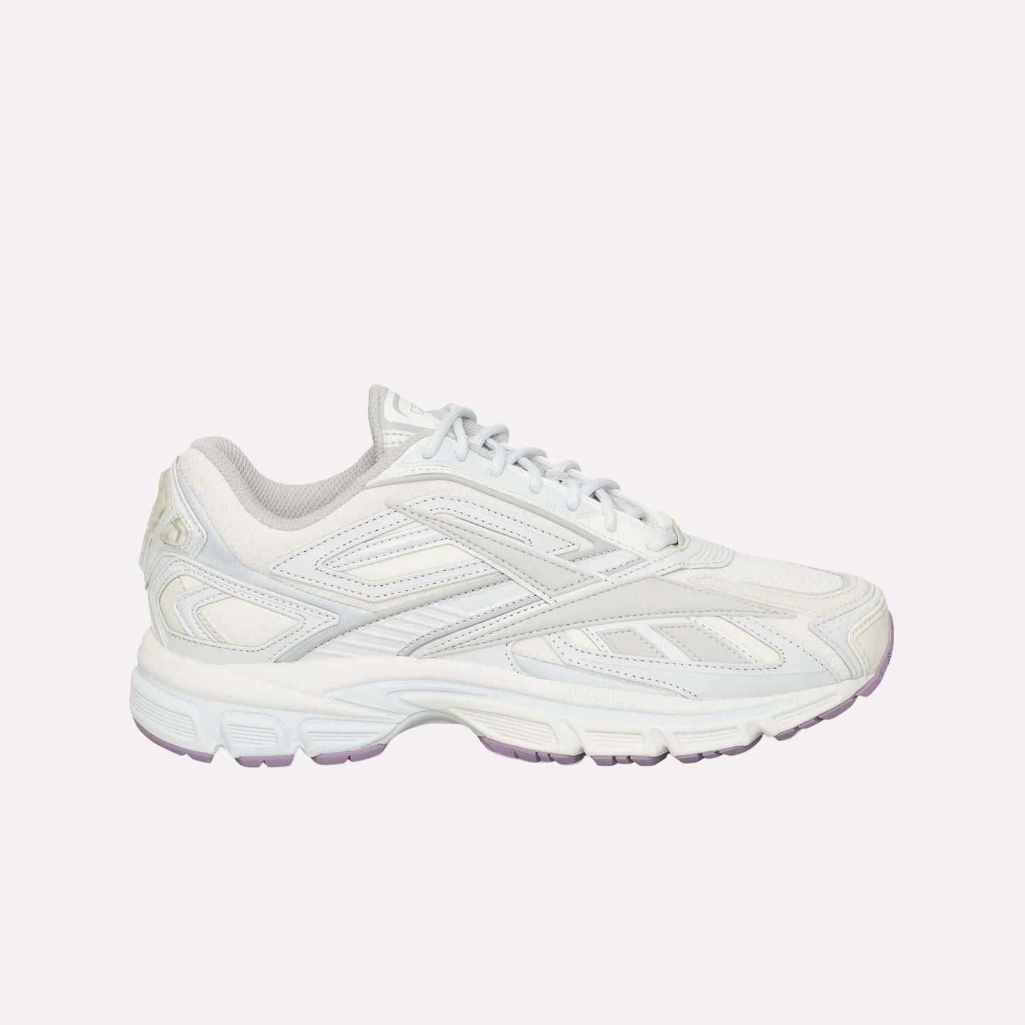 A white athletic sneaker with light gray accents, a textured sole, and lace-up closure is displayed on a plain white background. The Reebok Premier Road Ultra LTD Shoes are inspired by archival running sneaker design and feature a supportive dual-density midsole for enhanced comfort and performance.