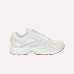 A white athletic sneaker with light gray accents, a textured sole, and lace-up closure is displayed on a plain white background. The Reebok Premier Road Ultra LTD Shoes are inspired by archival running sneaker design and feature a supportive dual-density midsole for enhanced comfort and performance.