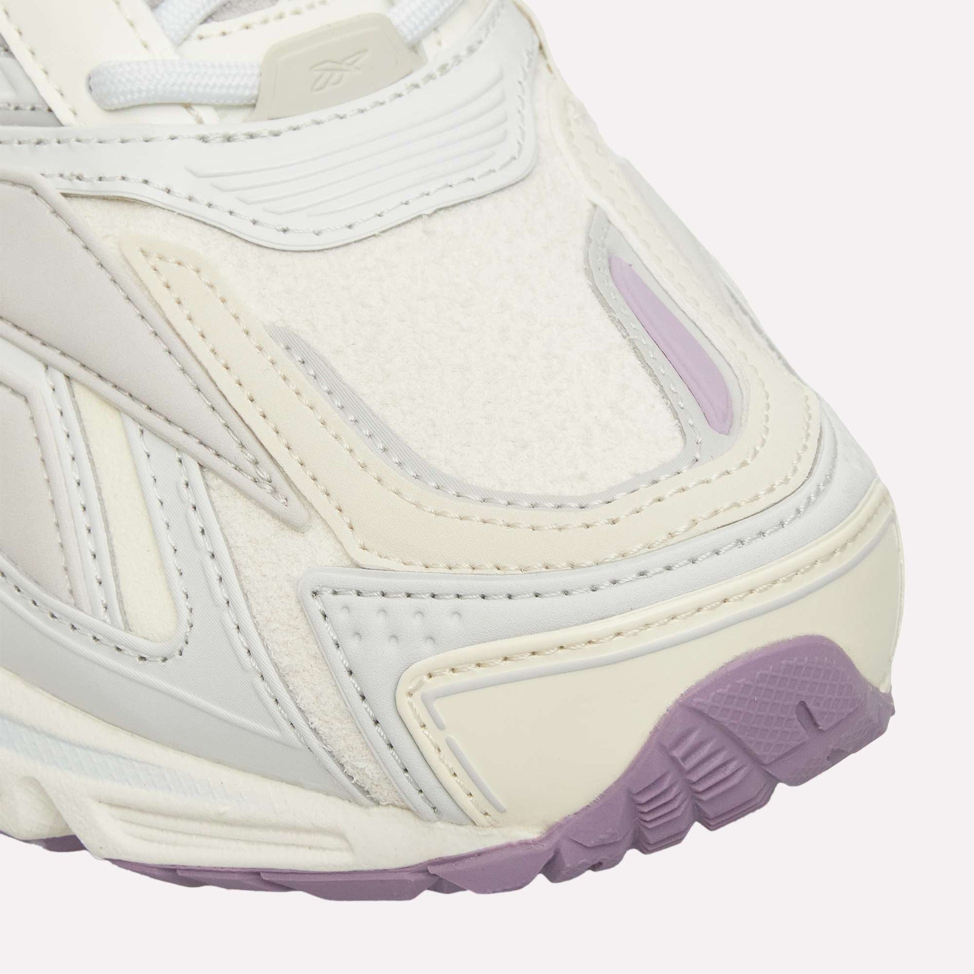 Close-up of the Reebok Premier Road Ultra running sneaker’s front, featuring detailed stitching, layered materials, a dual-density midsole, and a textured sole with lavender accents.