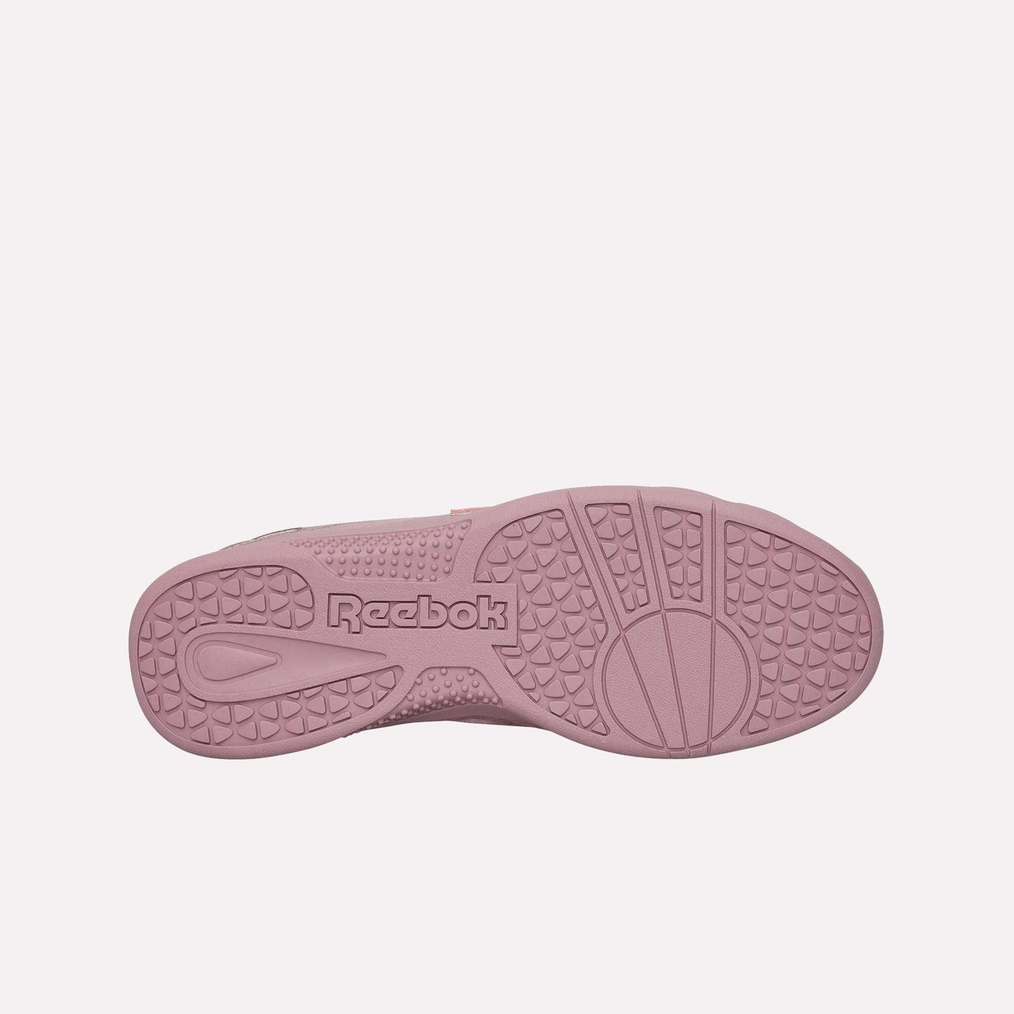 The image shows the sole of the Reebok Hammer Pro Ltd sneaker in pink, with textured grip patterns and a central Reebok logo. Its durable rubber sole emphasizes both quality and style.