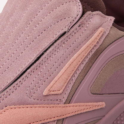 Close-up of the Reebok Hammer Pro Ltd sneakers, featuring a mauve suede upper with pink and tan mesh, visible stitching, layered styling, and a durable rubber sole for a modern textured look.