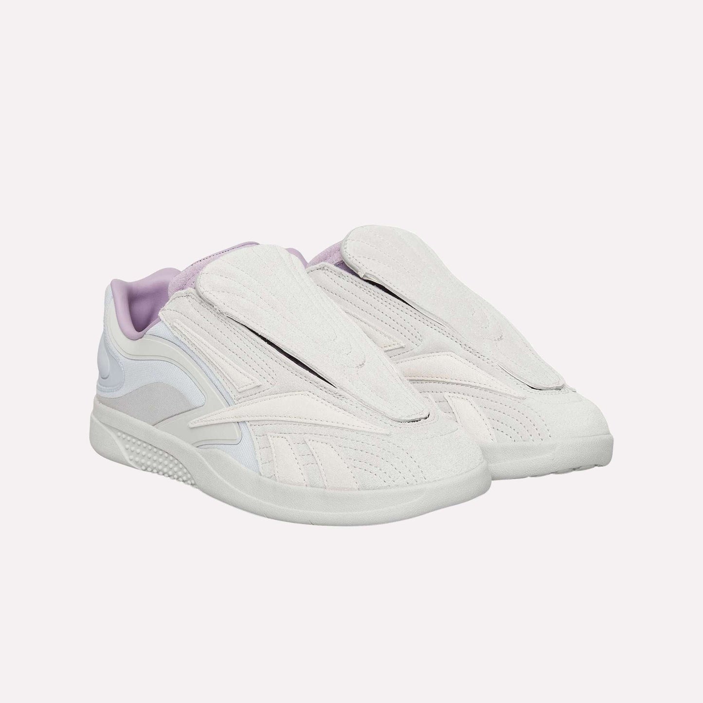 The Reebok Hammer Pro Ltd features light beige and lavender suede uppers with covered laces, a modern sporty design, and a flat durable rubber sole.