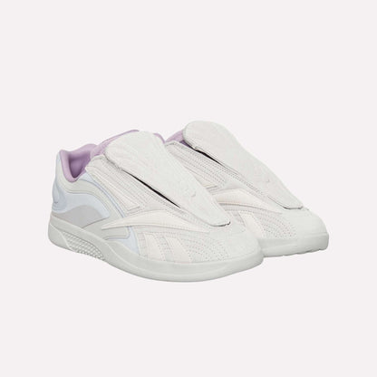 The Reebok Hammer Pro Ltd features light beige and lavender suede uppers with covered laces, a modern sporty design, and a flat durable rubber sole.