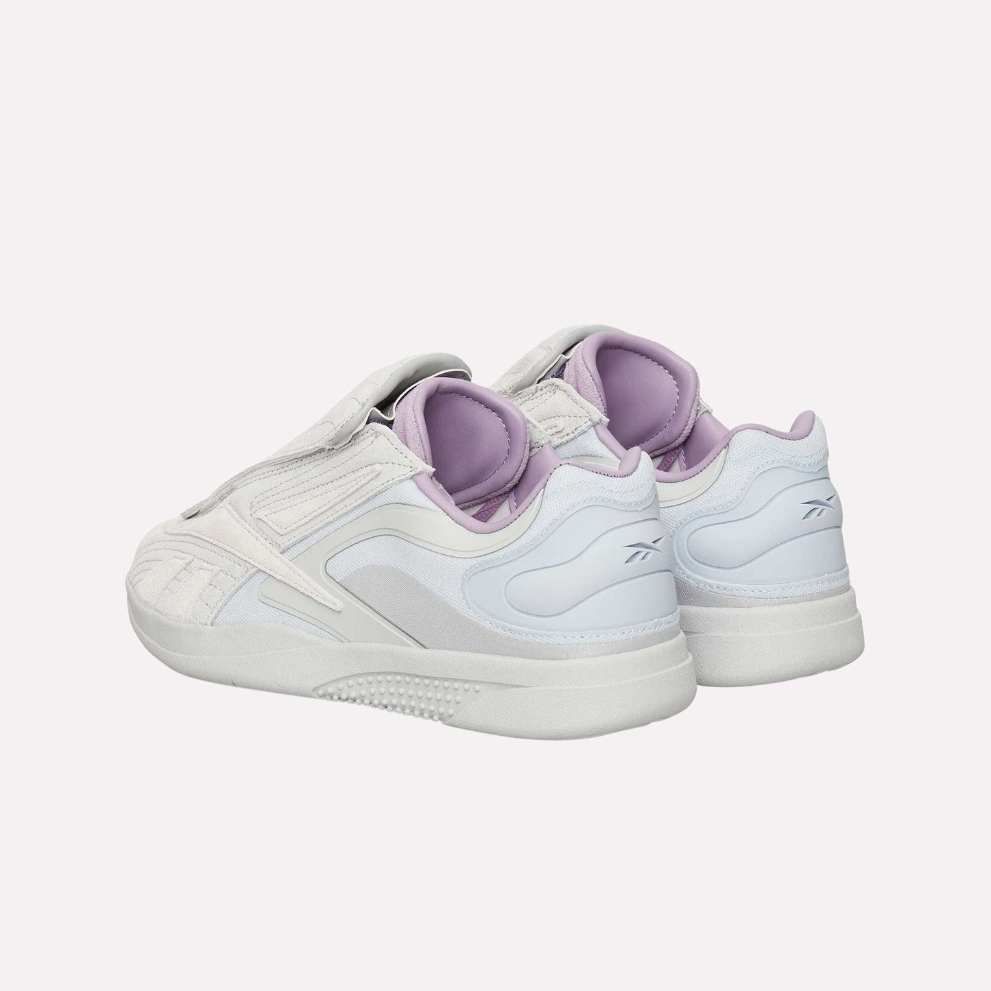 The Reebok Hammer Pro Ltd sneakers, featuring a suede upper and light purple accents on the lining and heel, are displayed from a rear side angle against a plain white background.