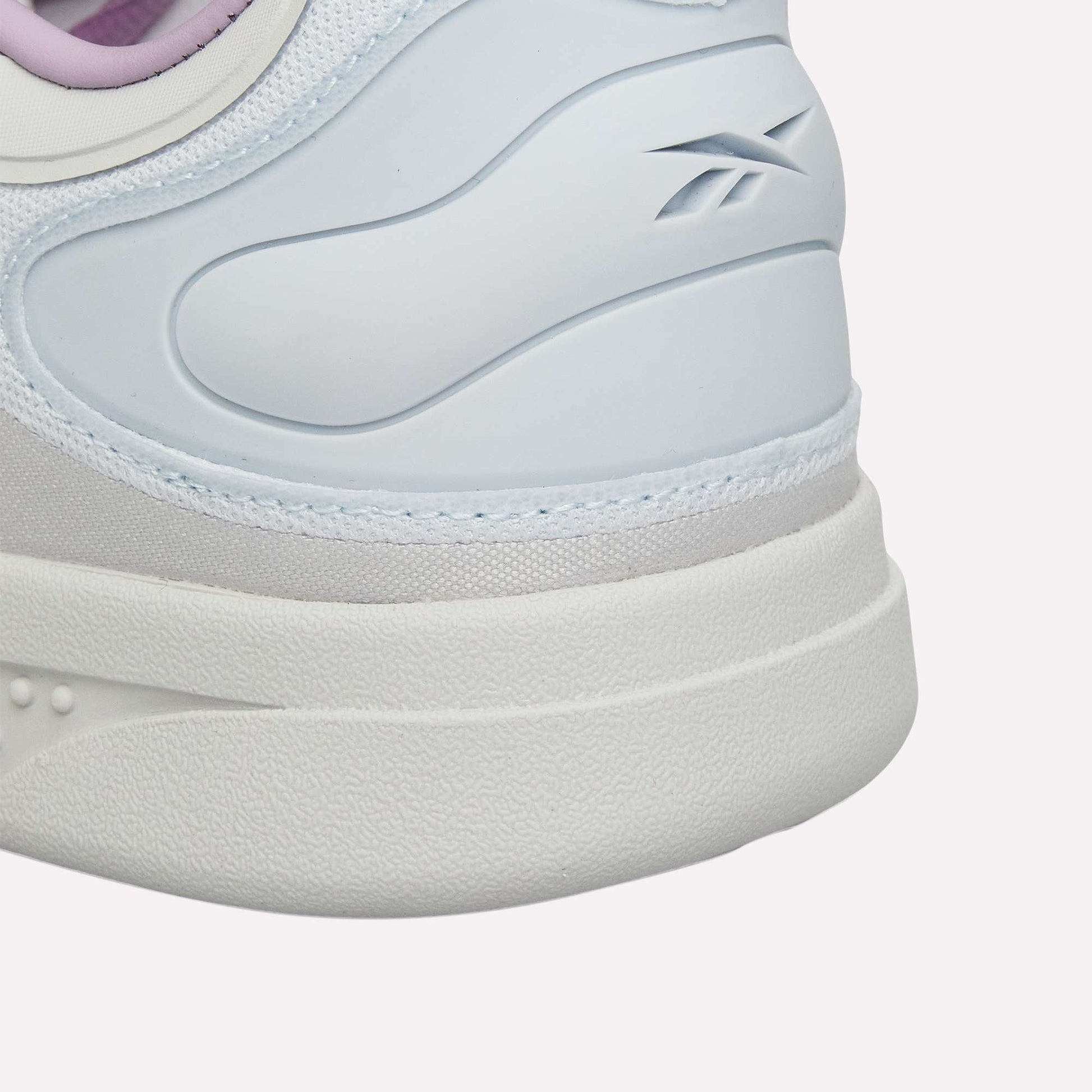 Close-up of the heel on Reebok Hammer Pro Ltd sneakers, showing a durable rubber sole, white and light blue hues, subtle branding, and a touch of purple at the top edge.