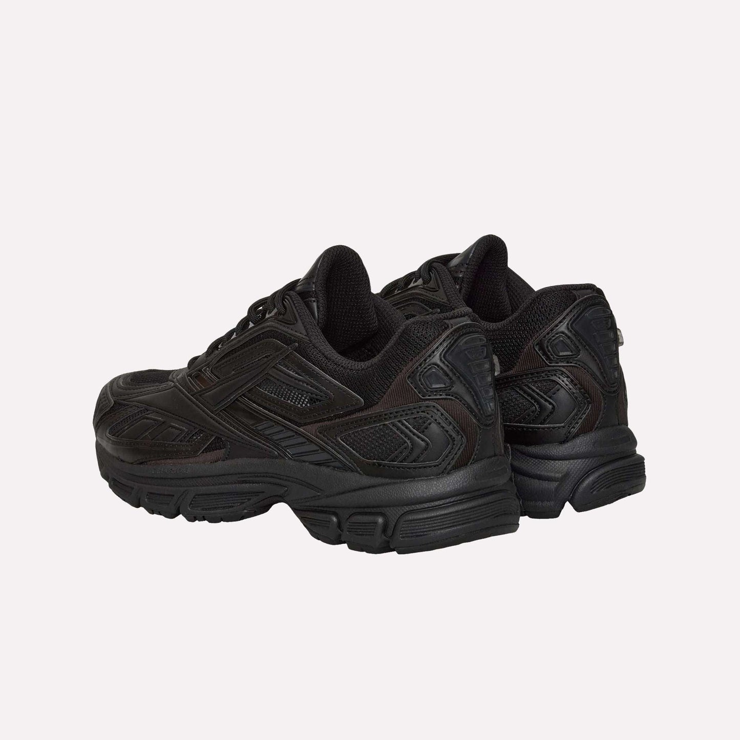 A pair of black Reebok Premier Road Ultra sneakers with textured details, seen from the back and side, featuring dual-density midsoles, thick soles, and padded collars.