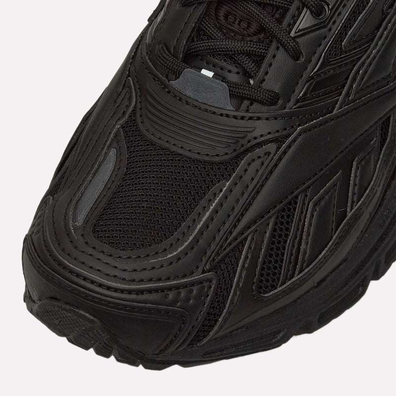 Close-up of the front and side of the Reebok Premier Road Ultra in black, highlighting detailed stitching, mesh upper, textured rubber sole, and dual-density midsole.