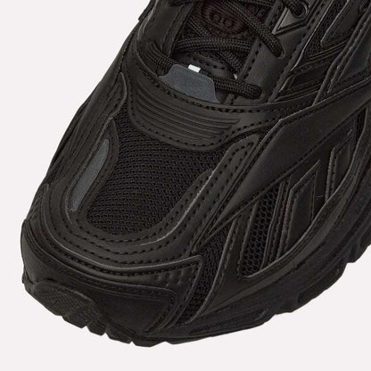 Close-up of the front and side of the Reebok Premier Road Ultra in black, highlighting detailed stitching, mesh upper, textured rubber sole, and dual-density midsole.