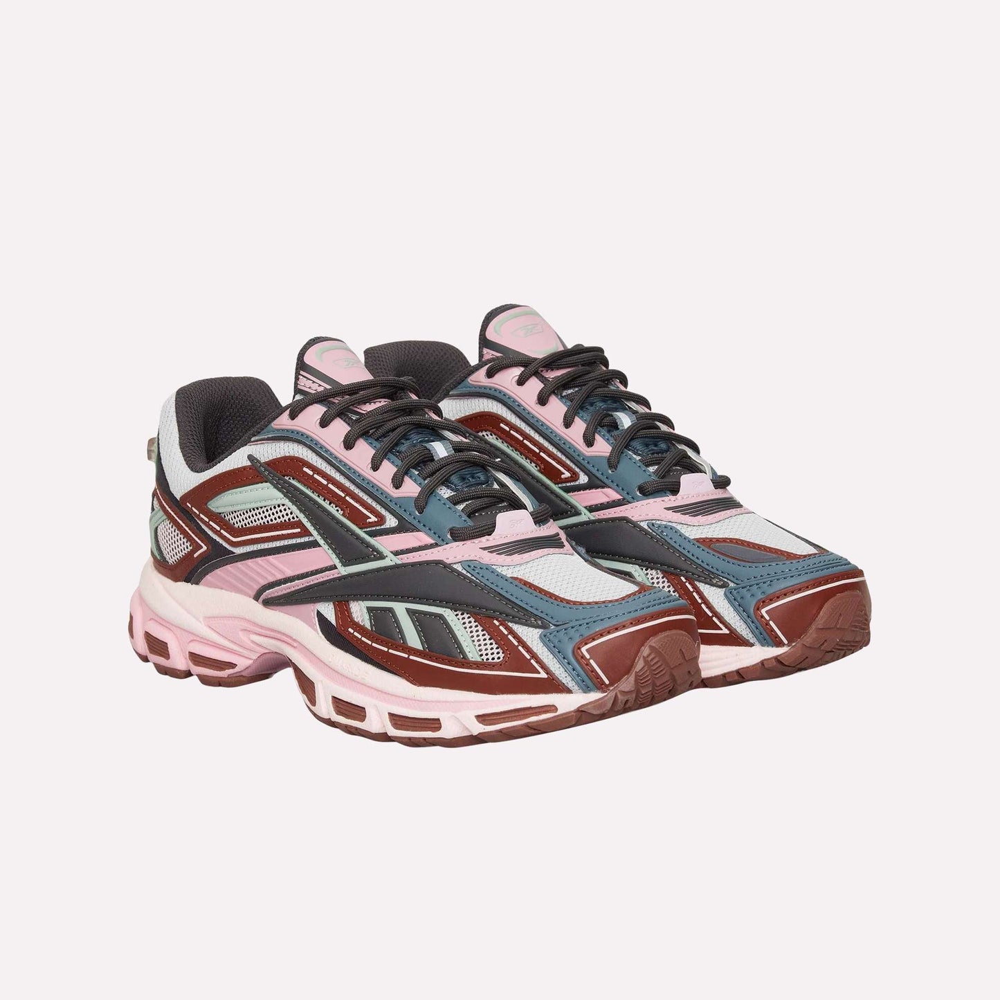 The Reebok Premier Road Ultra is a stylish archival running sneaker featuring pink, maroon, grey, blue, and black colors with mesh panels, chunky soles, a dual-density midsole, and detailed overlays.