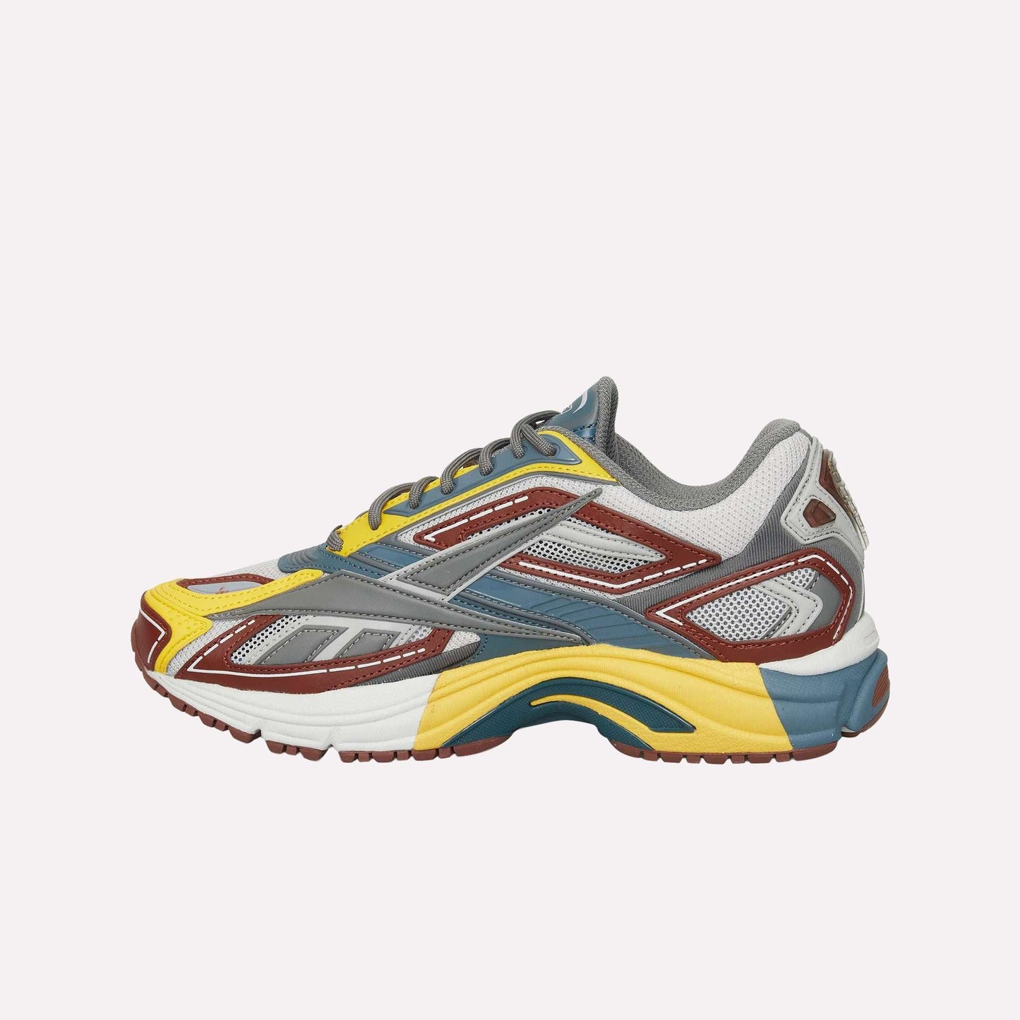 The Reebok Premier Road Ultra is a colorful running sneaker featuring yellow, brown, gray, blue, and white panels with mesh accents and a thick dual-density midsole for sporty modern style.