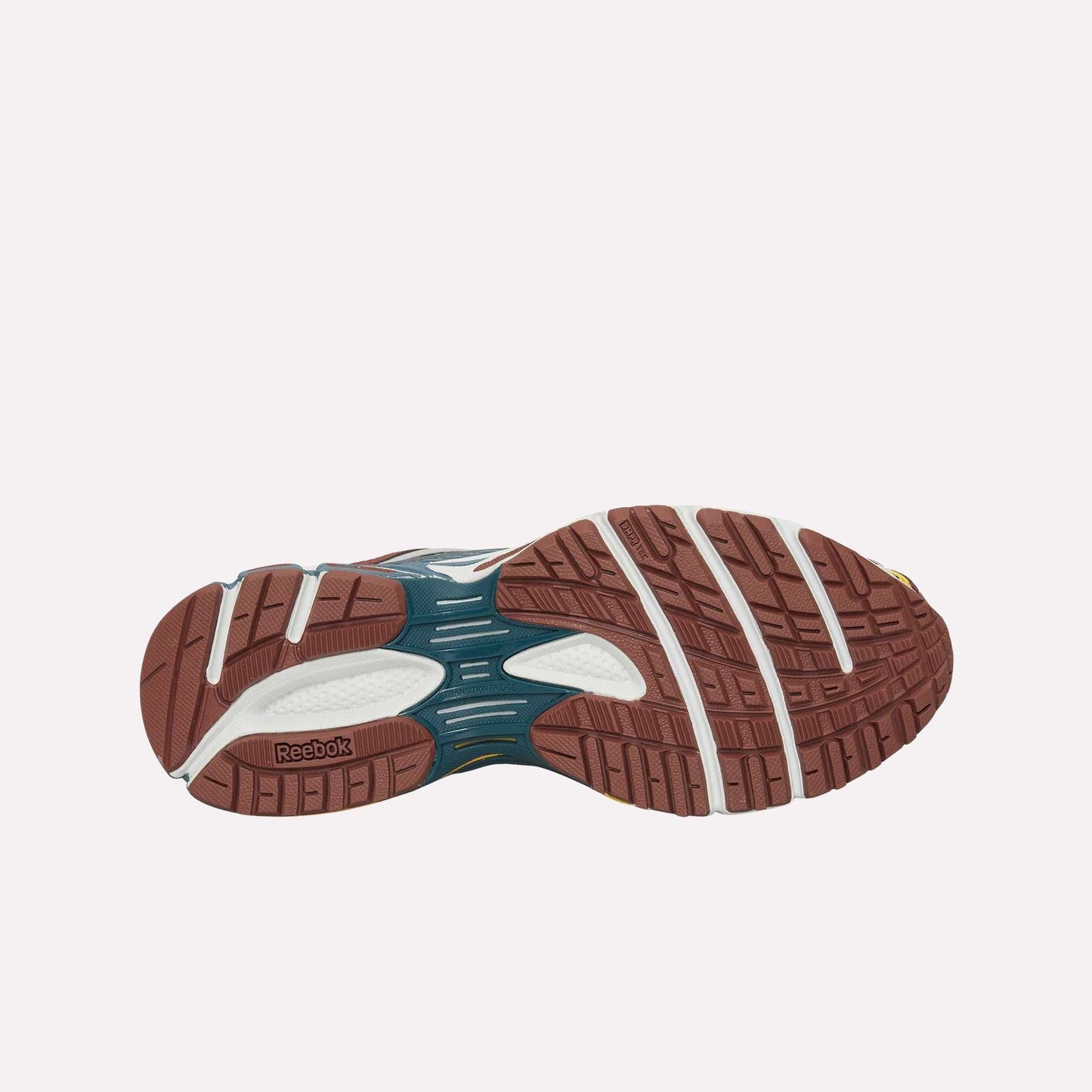 The image displays the sole of the Reebok Premier Road Ultra, featuring a brown and white tread pattern for traction and support. A dual-density midsole and the Reebok logo are visible near the heel on the side of the sole.
