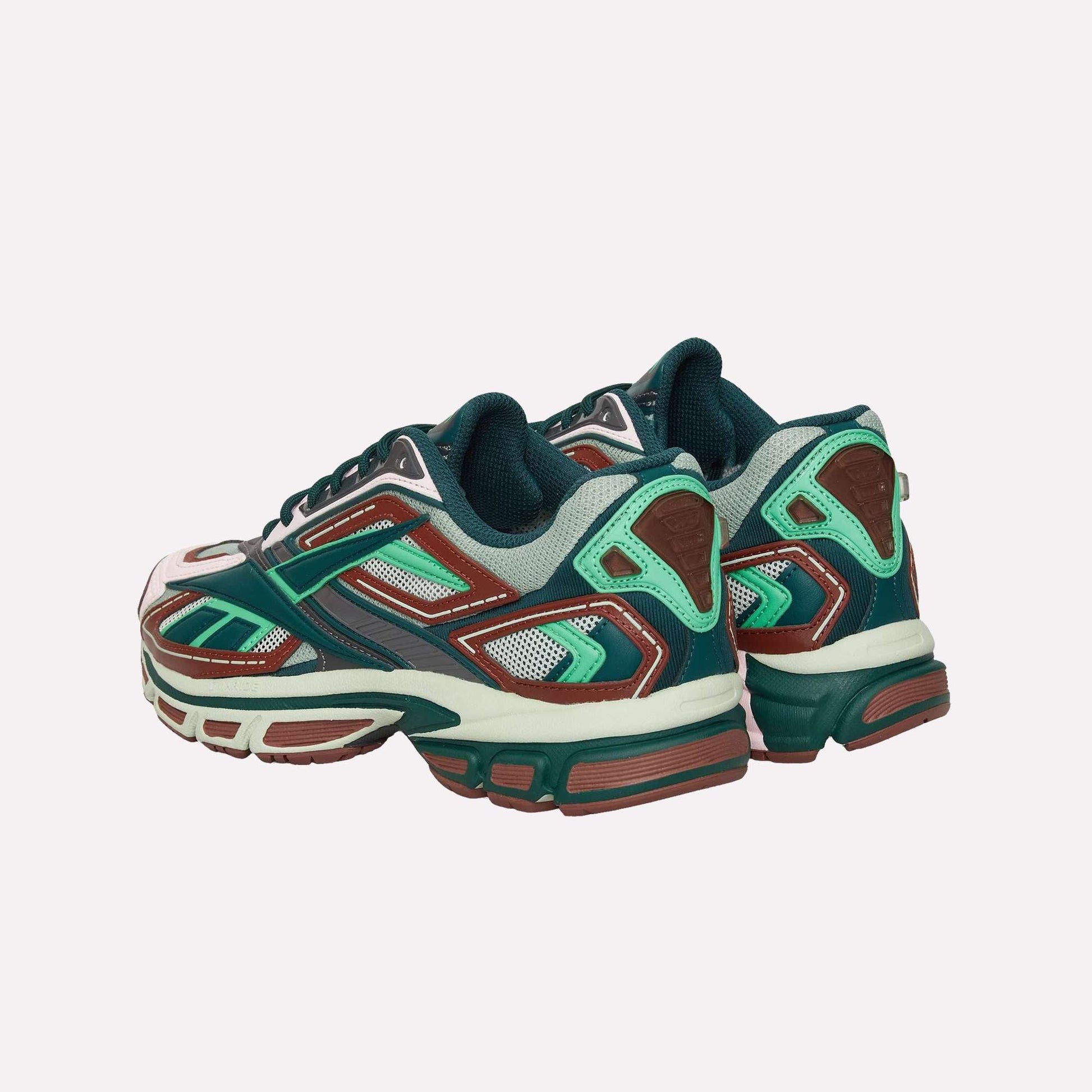 The Reebok Premier Road Ultra sneakers feature a stylish mix of green, teal, brown, and white, displayed from a rear side angle on a white background.